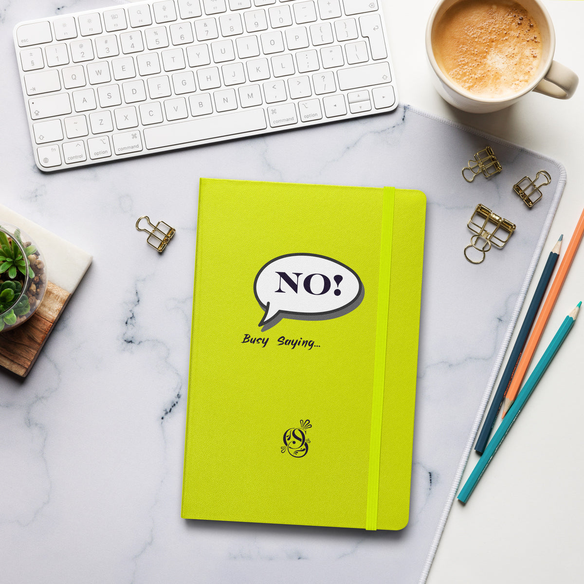 Chartreuse hardcover notebook lying on a desk beside a coffee cup and pens.